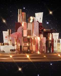 Elegant pink and gold beauty products arranged on a glamorous reflective surface.