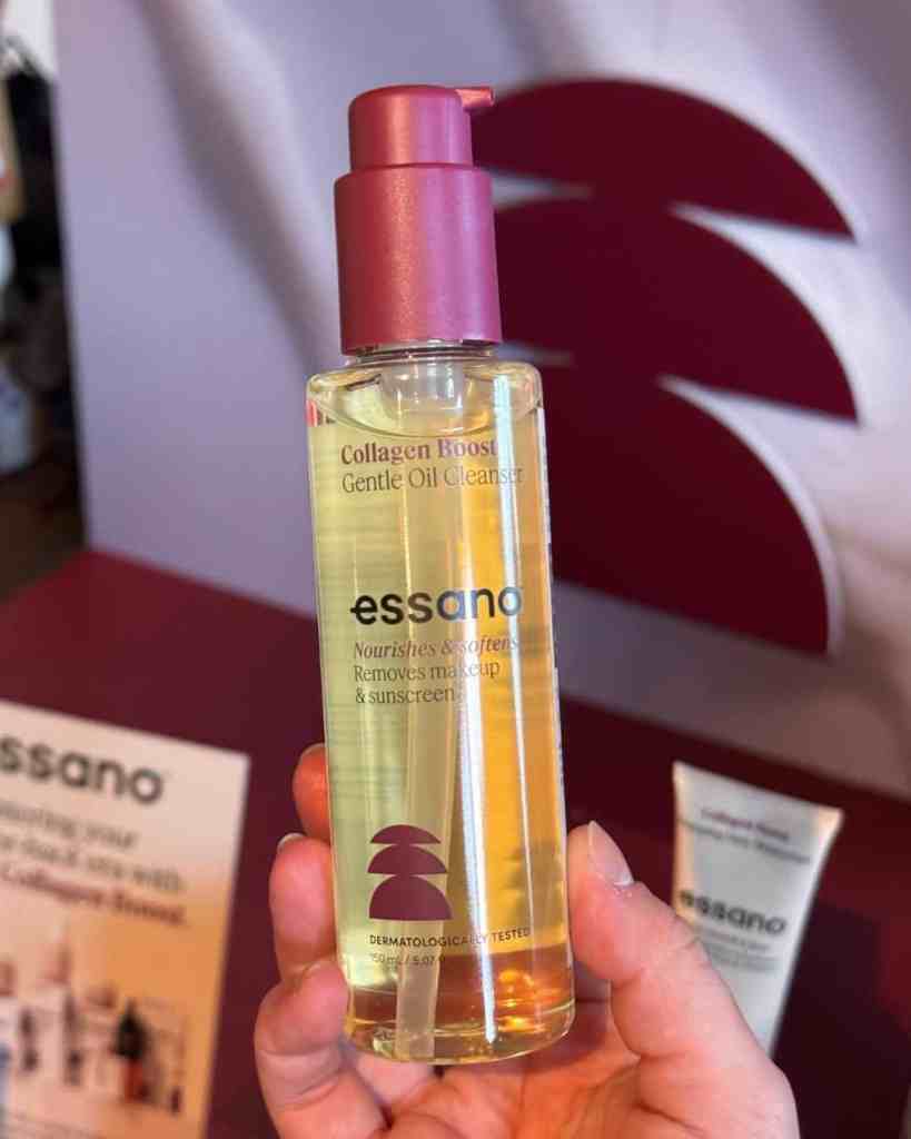 Image of Essano collagen boost gentle oil cleanser with pink pump top held in hand.