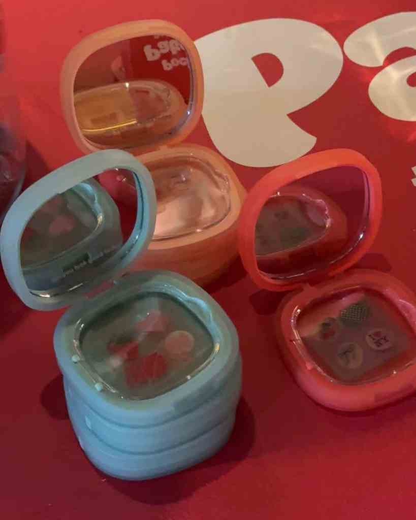 Vibrant collection of pastel and bright coloured glasses on a red table, perfect for social gatherings.
