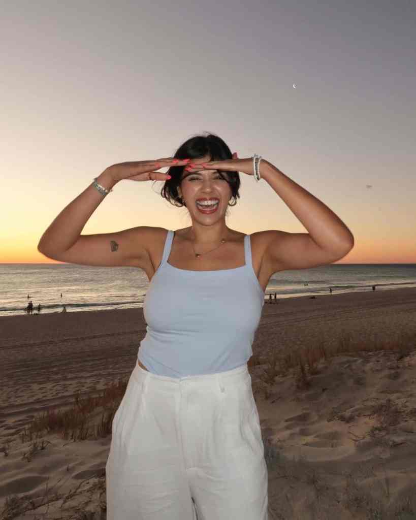 Happy woman enjoying sunset on the beach at dusk.