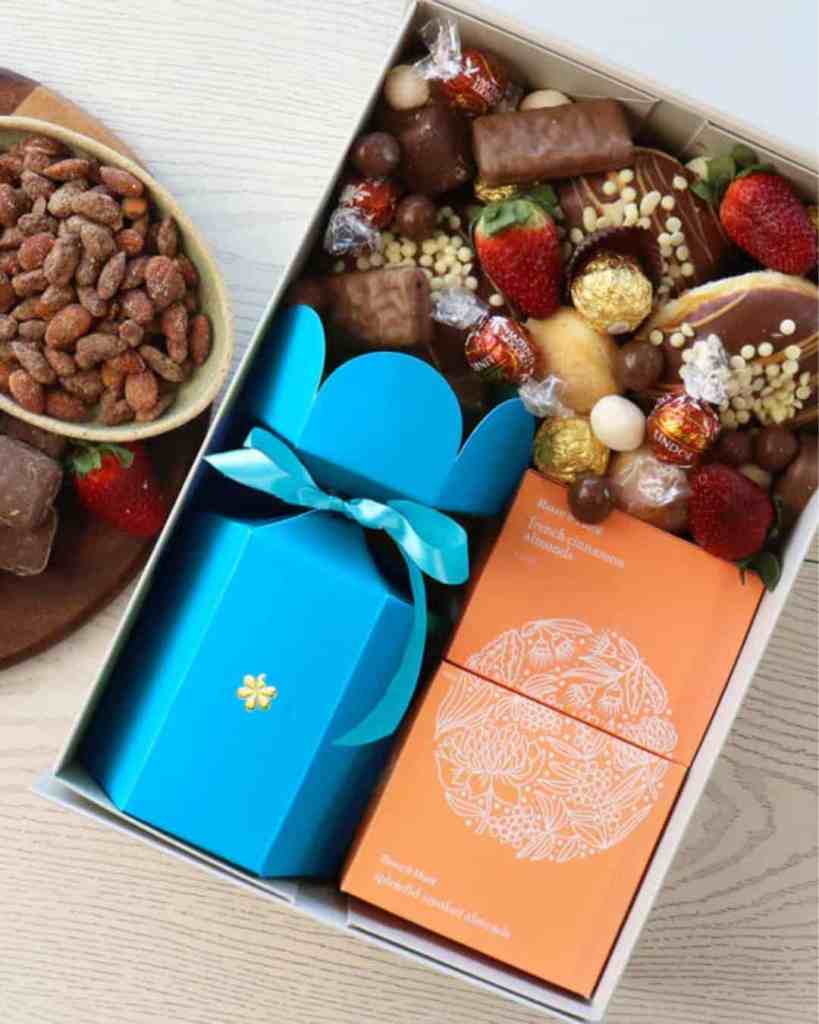 Bright blue gift box with chocolates and strawberries for special occasions.