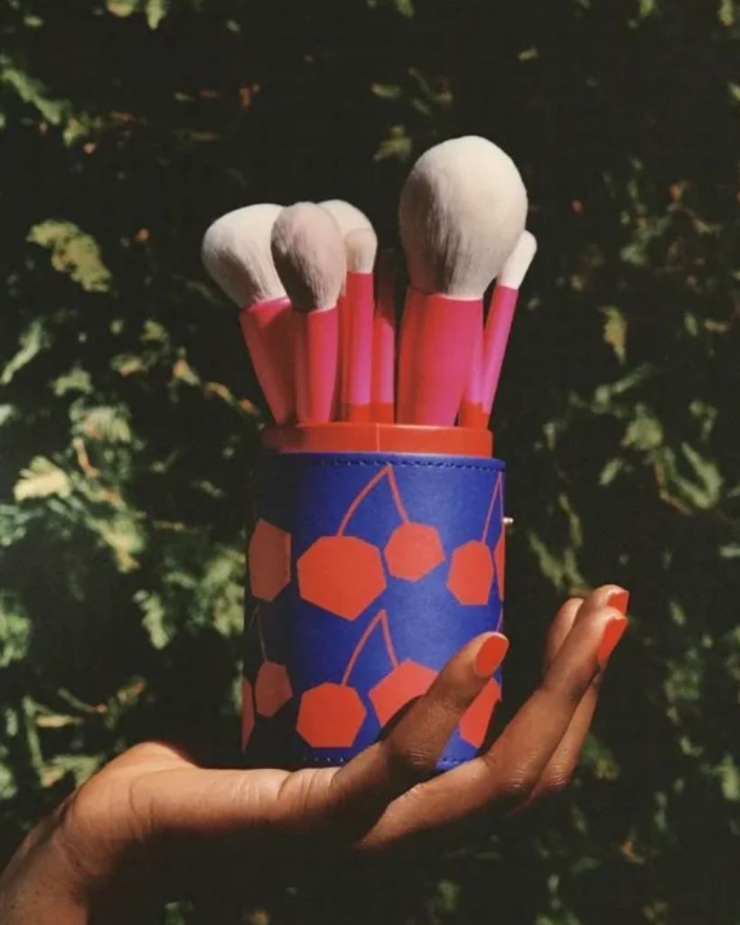 Clean makeup brushes standing upright in a travel brush holder