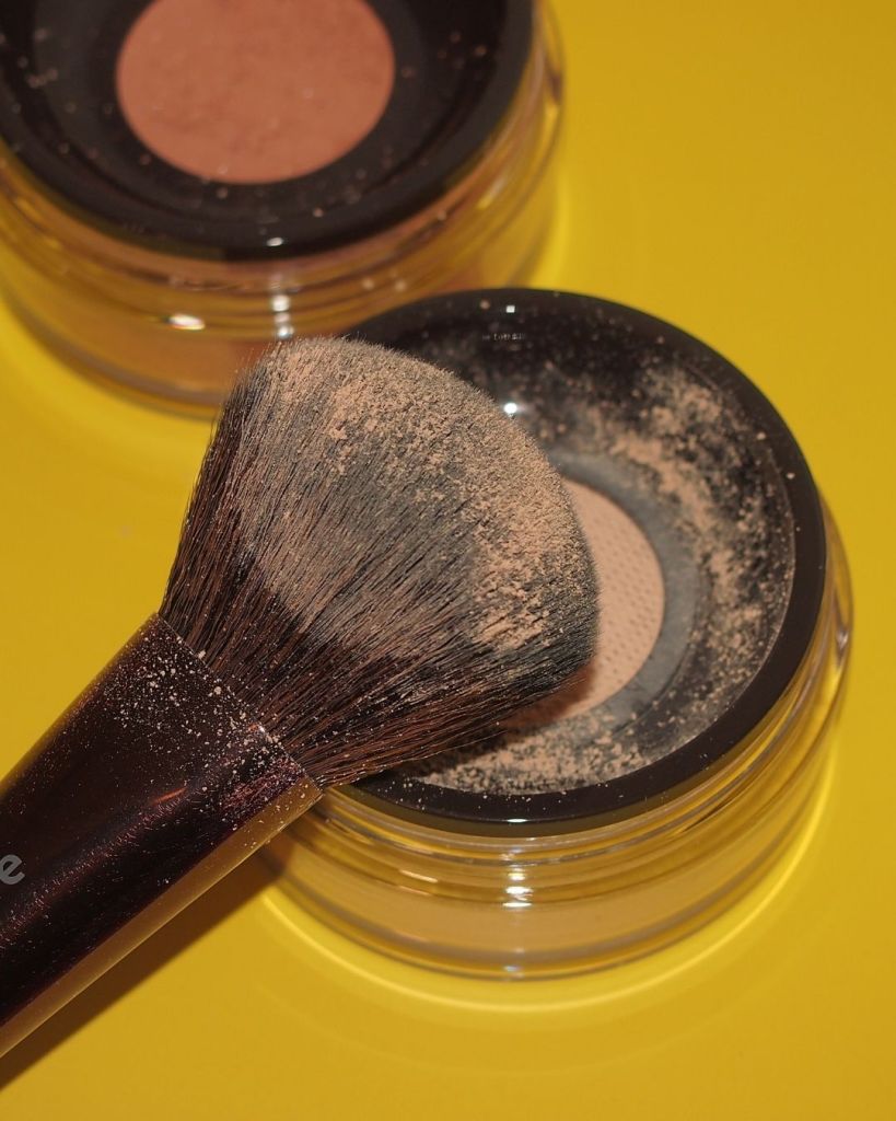 Dense powder makeup brush with heavy product buildup ready for cleaning