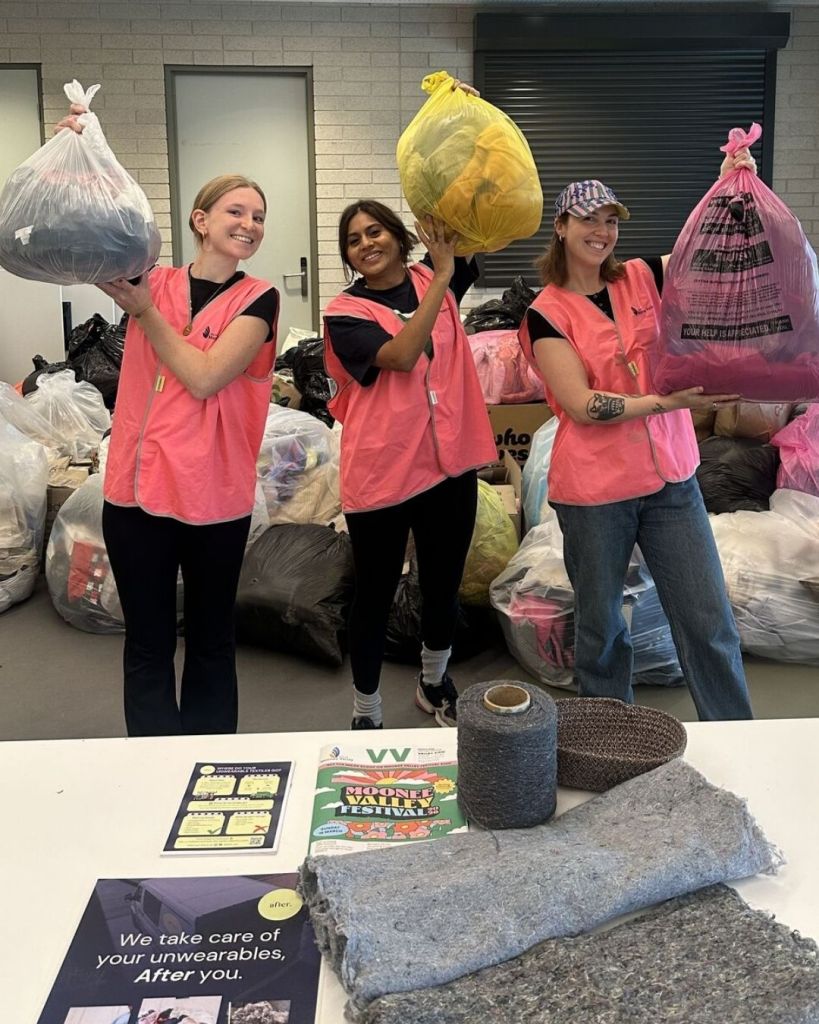 Three After team members holding bags of collected clothing beside recycled yarn and felt samples